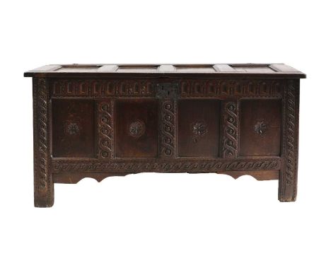 A carved oak coffer, 18th century, the rectangular hinged top above triple panelled front  151cm wide 56cm deep 75cm highCond