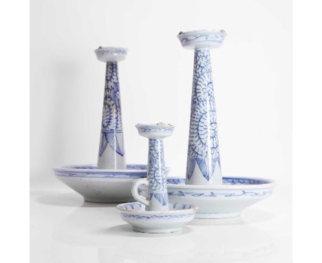 A collection of three Chinese blue and white candlesticks, c.1900, each with a circular drip tray surmounted by a tapering co