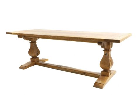 An oak refectory table, of recent manufacture, the boarded top with cleated ends, on baluster supports descending onto sledge