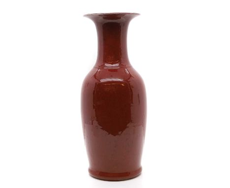 A Chinese red-glazed vase, early 20th century, of baluster form with a flared rim, covered under a rich oxblood glaze, with a