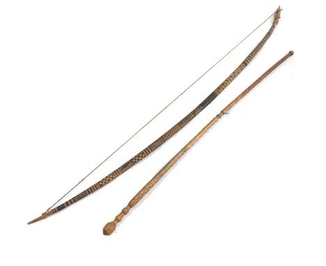 A hunting bow, probably Oceanian, 20th Century, with geometric decoration in black, 151cm long, together with a carved and in