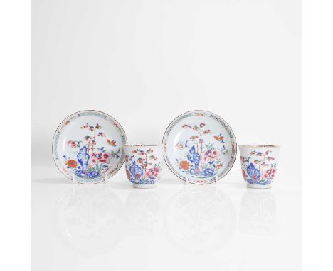 A pair of Chinese export famille rose cups and saucers, 18th century, each painted with a butterfly flying above peony and ch