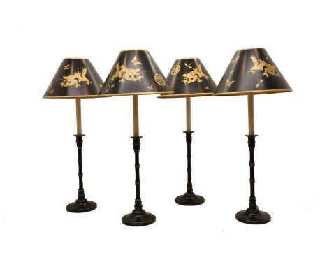 A set of four table lamps, 20th century, the black and gold conical shades with dragon motifs, on a slender turned column and