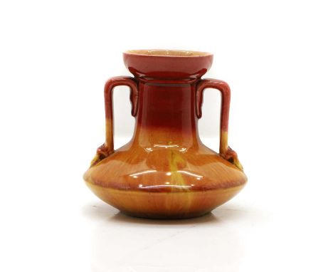 A Linthorpe twin handled vase, designed by Dr Christopher Dresser, in a red and orange trailing glaze, impressed marks and nu