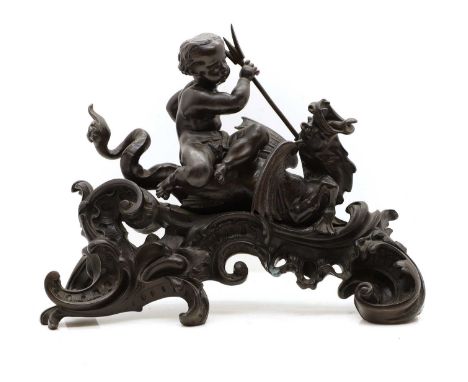 A Louis XV style patinated bronze chenet, with a putto holding a trident and riding a sea dragon on a rococo scrolling wave,4