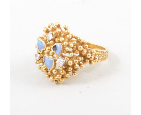 An 18 carat yellow gold modern dress ring, three heart shape motifs each set with an opal and three claw set brilliant cut di