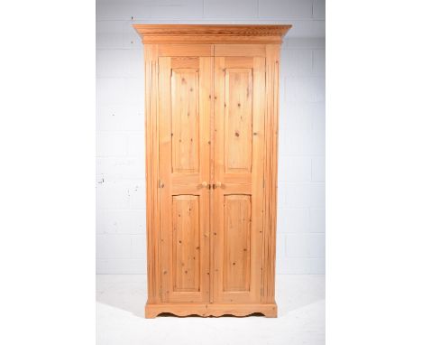 Modern pine double wardrobe, moulded cornice, two panelled doors, bracket feet, width 101cm, height 194cm.