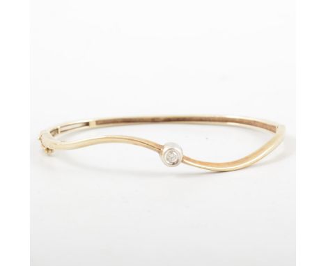 A gold bangle set with a diamond solitaire, the brilliant cut stone collet set and mounted to the centre of a 2.2mm wide 9 ca