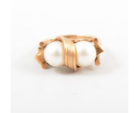 A cultured pearl dress ring, two 7.5mm pearls, set side by side in an all yellow metal mount marked 14k, plain shank with spl