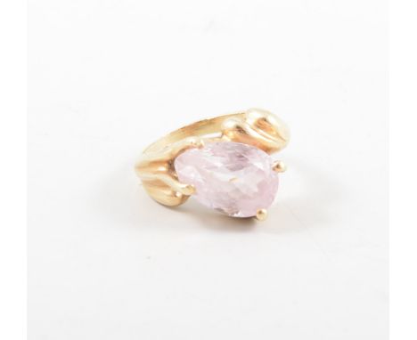 A pink stone dress ring, the pear shaped stone 15mm x 10mm, four claw set in an all yellow metal mount, gross weight approxim