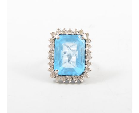 A large blue stone cluster ring, the multi faceted rectangular turquoise blue stone 20mm x 15mm, surrounded by twenty-four br