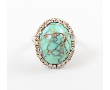 A turquoise matrix and diamond oval cluster ring, the oval turquoise matrix 20mm x 15mm claw set and surrounded by twenty-eig