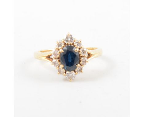 A sapphire and diamond oval cluster ring, the oval mixed cut sapphire surrounded by ten individually claw set brilliant cut d