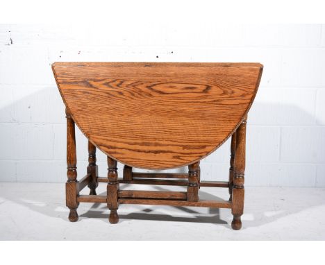 Oak table, oval top with two drop leaves, moulded edge, turned gate legs, the top 92cm x 130cm, height 73cm.