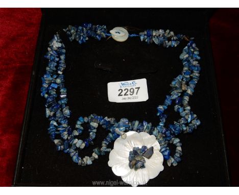 A triple strand necklace of Lapis Lazuli stones with mother of pearl floral pendant and fastenings.