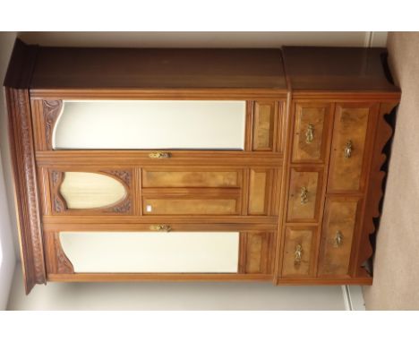 Edwardian walnut and figured walnut wardrobe, shield aperture, two bevelled mirror glazed doors, five drawers to base, carved