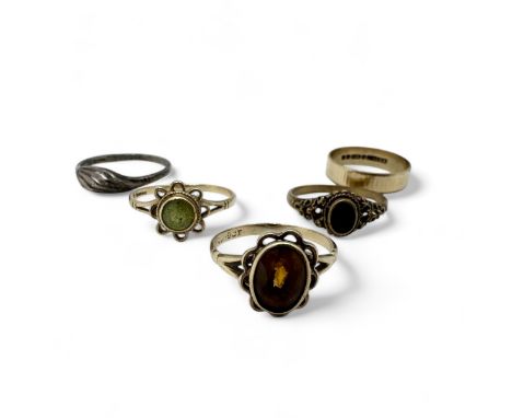A group of five rings to include 9ct gold examples. Comprising a 9ct gold textured band ring, size R; a "9ct" stamped and tes