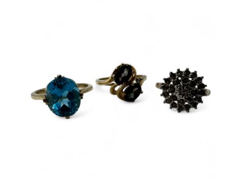 A group of three 9ct gold gem set dress rings.  A Swiss blue topaz dress ring, size R; an illusion set diamond cluster ring, 