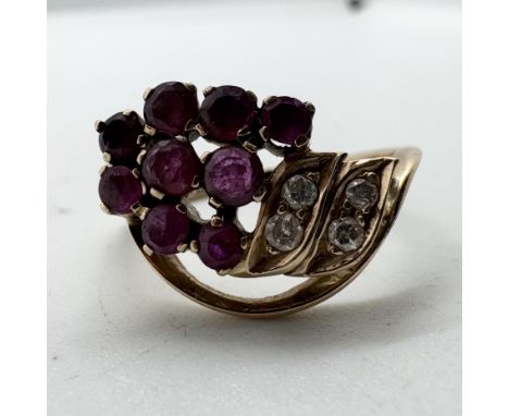 A ruby and diamond set dress ring in the form of a bunch of grapes. Set with nine round cut rubies and four round brilliant c