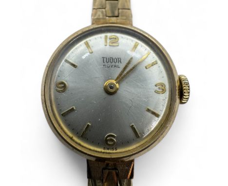 A ladies 9ct gold Tudor cocktail watch on 9ct gold textured link bracelet. With a silvered dial and gold baton/Arabic numeral