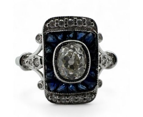 A diamond and sapphire Art Deco style target ring, set with a central antique style cushion cut diamond of an estimated 0.53 