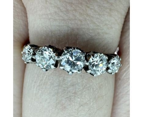A five stone diamond set half hoop ring. Claw set with five graduated old European round cut diamonds, ranging in diameter fr