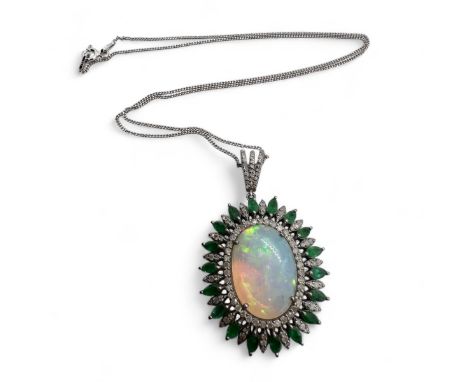 A statement opal, diamond and emerald set silver pendant. Featuring a 7.54 carat opal cabochon, with a largely green-blue pla