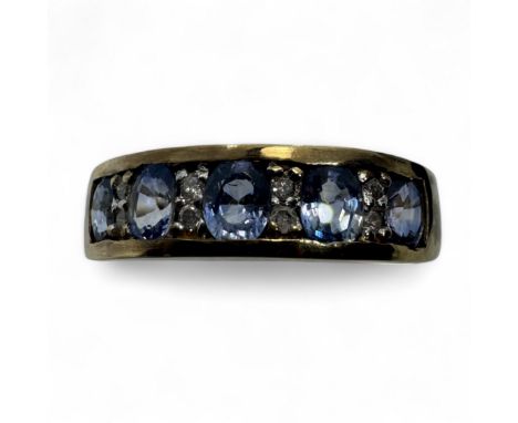 A diamond and sapphire set half hoop dress ring, in yellow precious metal. Set with five purplish-blue oval, mixed cut sapphi