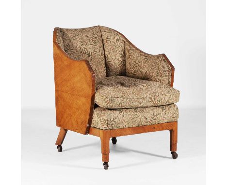 Arts and Crafts, an armchair, early 20th century, the maple frame raised on four brass caps and castors, upholstered in a Wil