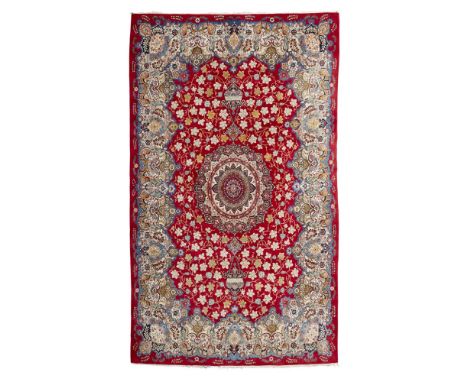 KASHAN CARPET  CENTRAL PERSIA, MID 20TH CENTURY   the red field with cream and red medallion, within shaped polychrome foliat