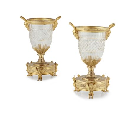 PAIR OF FRENCH GILT BRASS MOUNTED CRYSTAL URNS  19TH CENTURY   with twin-form mask handles above cut crystal bowls, raised on