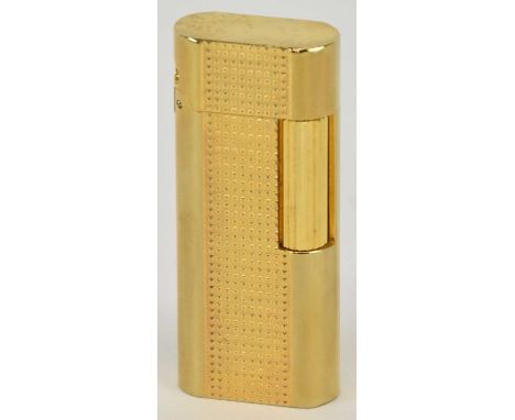 IN THE STYLE OF CARTIER; a boxed gold plated cigarette lighter, height 6cm, width 2.5cm.