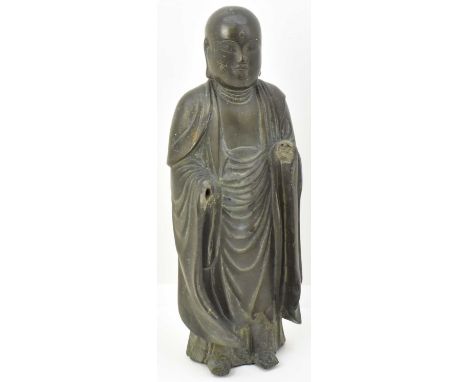A 19th century or earlier cast bronze figure of Jizo Bosatsu, shown with bald head, closed eyes and wearing oversized robe, w
