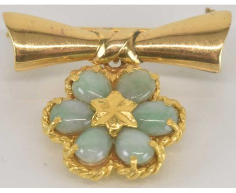 A Middle Eastern gold coloured metal brooch, the drop in the form of a flower head set with six small jade cabochons, suspend