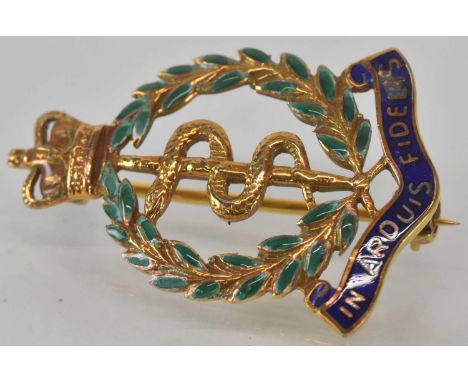 A 9ct yellow gold Royal Army Medical Corps regimental brooch decorated with the regimental emblem of the Rod of Asclepius, wi