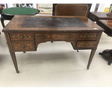 An Edwardian mahogany inlaid leather-topped desk on brass feet