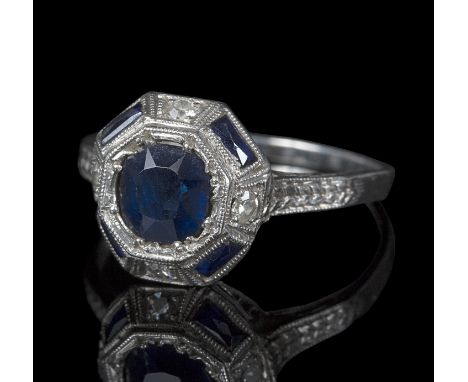 An Art Deco diamond and sapphire dress ring, the central sapphire approximately 0.6ct within an octagonal setting with four r