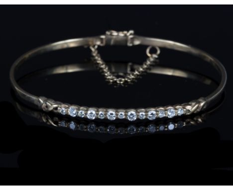 A diamond set bangle, the thirteen round brilliant cut diamonds to an unmarked yellow metal hinged mount, gross weight approx