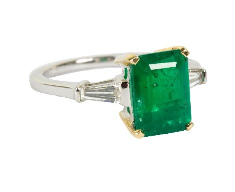 An emerald and diamond dress ring, the central rectangular step cut emerald approximately 2.49ct in a yellow metal four claw 