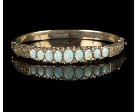 A Victorian opal and diamond bangle, set nine oval opal cabochon graduating in size from the centre, with fourteen round bril