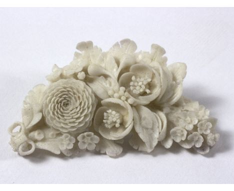 A ceramic floral spray brooch, 8cm long, in a leather jewellery box