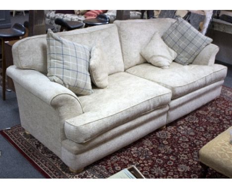 A large upholstered sofa, fitted loose seats and back cushions, 244cm wide