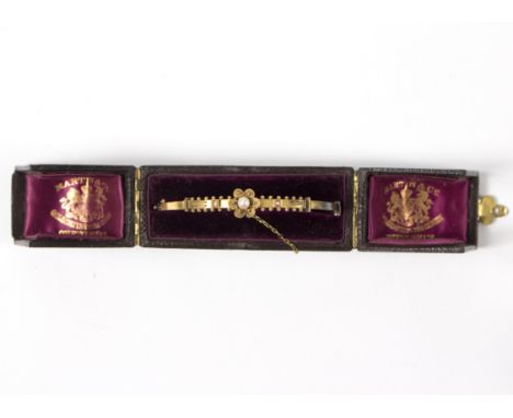 A Victorian yellow metal bangle, set a cultured pearl to a petal surround, unmarked, gross weight approximately 7.9gm, in fit