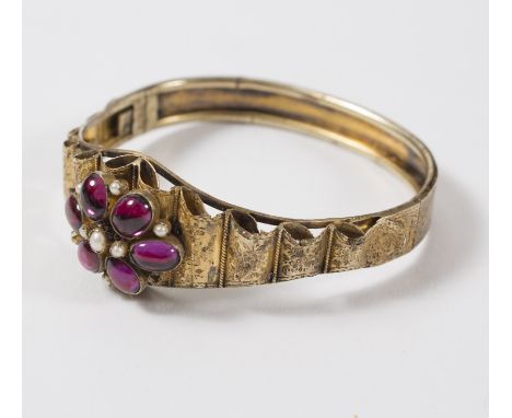 A Victorian gem set hinged bangle, the central cluster to engraved shoulders