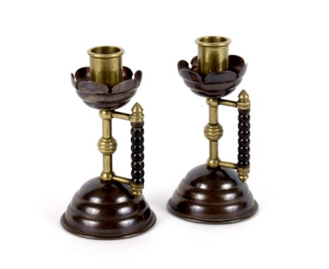 Christopher Dresser for Benham & Froud/Pair of Arts and Crafts brass and copper candlesticks, with bobbin turned fruitwood ha