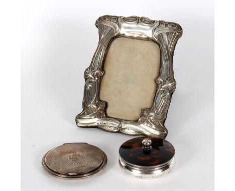 An Art Nouveau silver mounted photograph frame, Chester 1901, with scroll and flower decoration, 18.5cm high, an Art Deco sil
