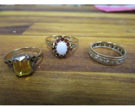 A 9ct gold opal and garnet ring, a yellow metal and white stone full eternity ring and a 9ct gold and silver ring set with an