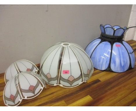 Two light fittings, one with blue and white mottled panels and another with clear and coloured glass panels 