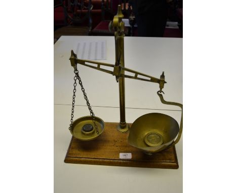 Pair of 19th Century brass balance scales with weights on a mahogany plinth