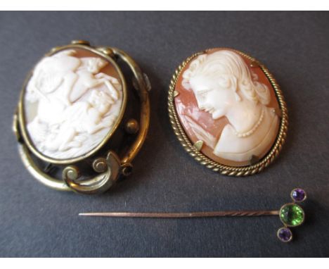 Two oval gilt mounted carved shell cameo brooches, together with a gold stick pin